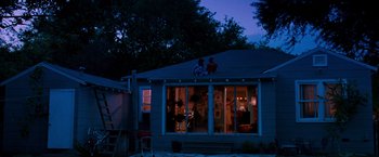 Movie still from “Selena” (1997), directed by Gregory Nava – Two people sitting on the roof of a house at night; Extreme Wide shot, Low angle