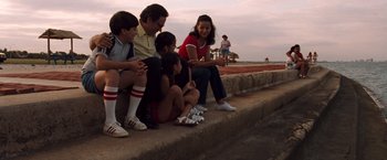 Movie still from “Selena” (1997), directed by Gregory Nava – A group of people sitting next to each other on a ledge; Wide shot, High angle