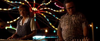 Movie still from “Selena” (1997), directed by Gregory Nava – A man and a woman standing next to each other at an amusement park; Medium shot, Low angle