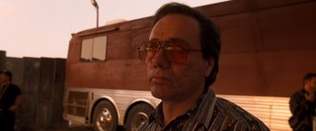 Movie still from “Selena” (1997), directed by Gregory Nava – A person wearing glasses near a bus; Close Up shot, Low angle