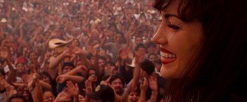 Movie still from “Selena” (1997), directed by Gregory Nava – A crowd of people in a stadium with a woman smiling; Close Up shot, Overhead angle