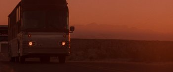 Movie still from “Selena” (1997), directed by Gregory Nava – A bus driving down a street at sunset; Extreme Wide shot, Low angle