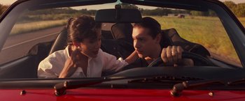 Movie still from “Selena” (1997), directed by Gregory Nava – A man and a woman sitting in the back seat of a car; Medium shot, Over the shoulder angle