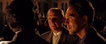 Movie still from “Selena” (1997), directed by Gregory Nava – Two men are looking at the camera while one of them is wearing a green cord around his neck; Close Up shot, Over the shoulder angle