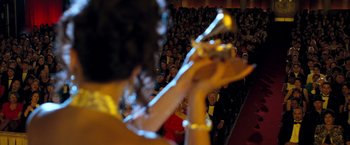 Movie still from “Selena” (1997), directed by Gregory Nava – A person playing a violin in front of an audience; Wide shot, Low angle