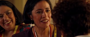 Movie still from “Selena” (1997), directed by Gregory Nava – An older woman wearing a red shirt and a yellow measuring tape around her neck; Close Up shot, Over the shoulder angle