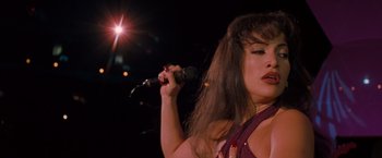 Movie still from “Selena” (1997), directed by Gregory Nava – A woman holding a microphone up to her face; Close Up shot, Low angle