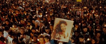 Movie still from “Selena” (1997), directed by Gregory Nava – A crowd of people holding candles and a picture of a woman; Wide shot, High angle