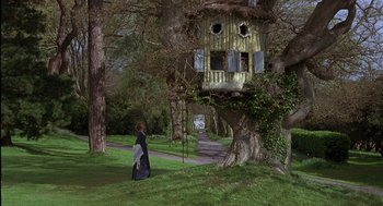Movie still from “Sense and Sensibility” (1995), directed by Ang Lee – A woman walking down a path near a tree house; Extreme Wide shot, Low angle
