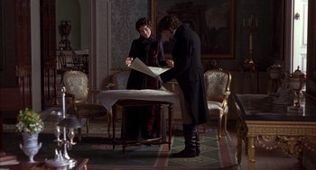 Movie still from “Sense and Sensibility” (1995), directed by Ang Lee – A man and a woman looking at a piece of paper on a table; Wide shot, High angle