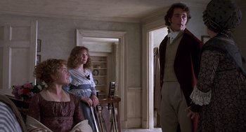 Movie still from “Sense and Sensibility” (1995), directed by Ang Lee – Two women and a man standing in a living room; Medium shot, Over the shoulder angle