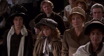 Movie still from “Sense and Sensibility” (1995), directed by Ang Lee – A group of people sitting in a row wearing hats; Medium shot, High angle