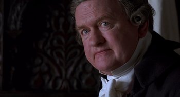 Movie still from “Sense and Sensibility” (1995), directed by Ang Lee – An older man wearing a white shirt and a white bow tie; Close Up shot, High angle