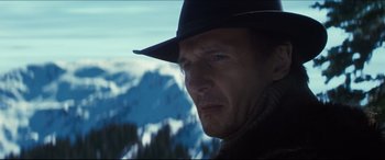 Movie still from “Seraphim Falls” (2006), directed by David Von Ancken – A person wearing a hat near a mountain; Close Up shot, Low angle