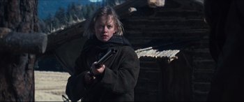 Movie still from “Seraphim Falls” (2006), directed by David Von Ancken – A young woman holding a gun in a dark place; Medium shot, Low angle
