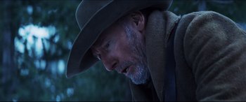 Movie still from “Seraphim Falls” (2006), directed by David Von Ancken – An older man wearing a cowboy hat looking down; Close Up shot, Low angle