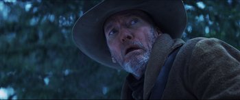 Movie still from “Seraphim Falls” (2006), directed by David Von Ancken – An old man with a beard and a hat looking up; Close Up shot, Low angle