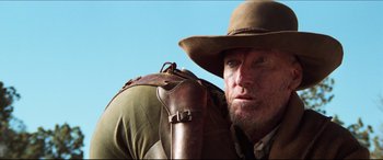 Movie still from “Seraphim Falls” (2006), directed by David Von Ancken – A person wearing a hat and holding a gun; Close Up shot, Low angle