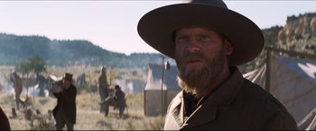Movie still from “Seraphim Falls” (2006), directed by David Von Ancken – A man with a long beard wearing a hat; Close Up shot, Over the shoulder angle