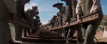 Movie still from “Seraphim Falls” (2006), directed by David Von Ancken – A group of men standing next to each other on some train tracks; Wide shot, Low angle