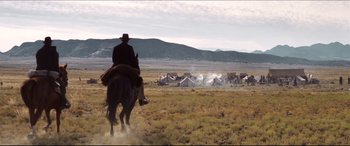 Movie still from “Seraphim Falls” (2006), directed by David Von Ancken – A man riding a horse in the middle of a field; Extreme Wide shot, Low angle