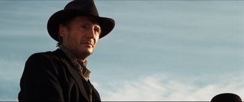 Movie still from “Seraphim Falls” (2006), directed by David Von Ancken – A man wearing a black hat and a black jacket; Close Up shot, Low angle
