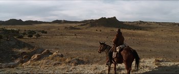 Movie still from “Seraphim Falls” (2006), directed by David Von Ancken – A man riding a horse in the middle of the desert; Extreme Wide shot, Low angle