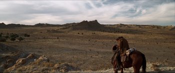 Movie still from “Seraphim Falls” (2006), directed by David Von Ancken – A man in a cowboy hat is standing in the desert; Extreme Wide shot, High angle