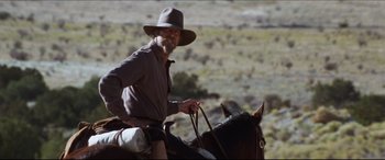 Movie still from “Seraphim Falls” (2006), directed by David Von Ancken – A man riding on the back of a brown horse; Medium shot, Low angle