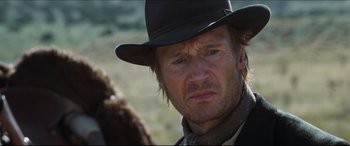 Movie still from “Seraphim Falls” (2006), directed by David Von Ancken – A person wearing a hat; Close Up shot, Over the shoulder angle