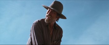 Movie still from “Seraphim Falls” (2006), directed by David Von Ancken – An older man wearing a gray hat and a brown shirt; Close Up shot, Low angle