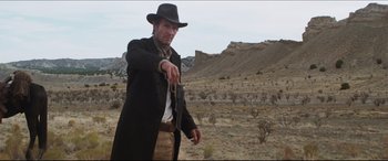 Movie still from “Seraphim Falls” (2006), directed by David Von Ancken – A man holding a gun in the middle of the desert; Medium shot, Low angle