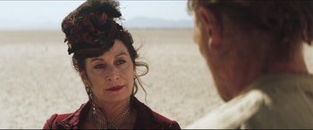 Movie still from “Seraphim Falls” (2006), directed by David Von Ancken – An older woman wearing a hat and a necklace; Close Up shot, Over the shoulder angle