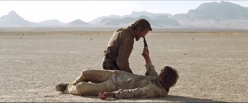 Movie still from “Seraphim Falls” (2006), directed by David Von Ancken – Two men are fighting in the middle of the desert; Wide shot, Over the shoulder angle