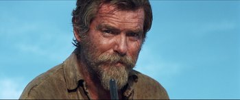Movie still from “Seraphim Falls” (2006), directed by David Von Ancken – A man with a long beard is holding something in his mouth; Close Up shot, Low angle