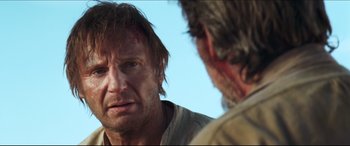Movie still from “Seraphim Falls” (2006), directed by David Von Ancken – A man looking at another man in a field; Close Up shot, Over the shoulder angle