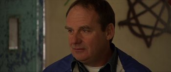 Movie still from “Session 9” (2001), directed by Brad Anderson – A person wearing a blue shirt; Close Up shot, Over the shoulder angle