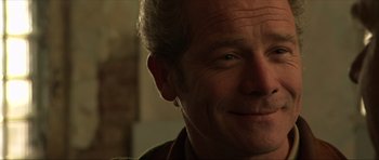 Movie still from “Session 9” (2001), directed by Brad Anderson – A man smiling for the camera; Close Up shot, Over the shoulder angle
