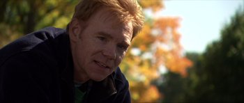 Movie still from “Session 9” (2001), directed by Brad Anderson – A person wearing a jacket near a tree; Close Up shot, Over the shoulder angle