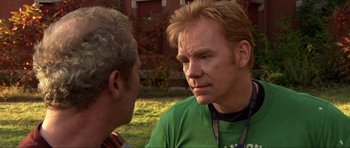 Movie still from “Session 9” (2001), directed by Brad Anderson – Two men talking to each other in the grass; Close Up shot, Over the shoulder angle