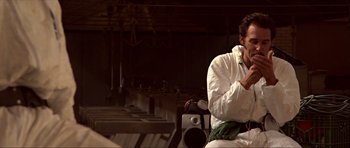 Movie still from “Session 9” (2001), directed by Brad Anderson – A man sitting on a chair in a room; Medium shot, Low angle