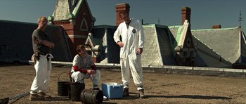 Movie still from “Session 9” (2001), directed by Brad Anderson – A man in white coveralls standing next to another man in white overalls; Wide shot, Low angle