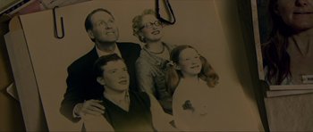 Movie still from “Session 9” (2001), directed by Brad Anderson – An old photo of a man , woman , and two children; Extreme Close Up shot, High angle