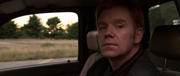 Movie still from “Session 9” (2001), directed by Brad Anderson – A man sitting in the back seat of a car looking out the window; Close Up shot, Over the shoulder angle