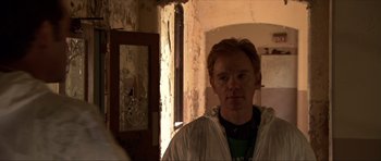 Movie still from “Session 9” (2001), directed by Brad Anderson – A man standing in front of a mirror in a room; Close Up shot, Over the shoulder angle