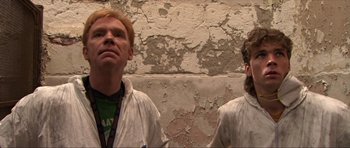 Movie still from “Session 9” (2001), directed by Brad Anderson – Two men standing next to each other wearing white shirts; Medium shot, Low angle