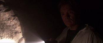 Movie still from “Session 9” (2001), directed by Brad Anderson – A man is holding a flashlight in the dark; Close Up shot, Low angle