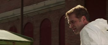 Movie still from “Session 9” (2001), directed by Brad Anderson – A man standing next to a brick building; Close Up shot, Low angle