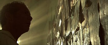 Movie still from “Session 9” (2001), directed by Brad Anderson – The sun is shining on a wall of papers; Wide shot, Low angle