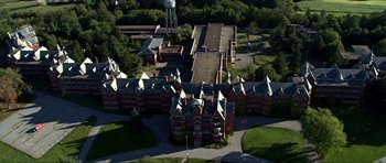 Movie still from “Session 9” (2001), directed by Brad Anderson – An aerial view of an old building with a water tower in the background; Extreme Wide shot, High angle